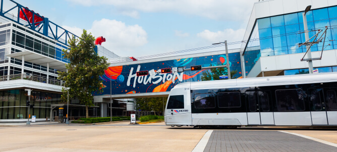 a METRORail vehicle traveling in front of the George R. Brown Convention Center.